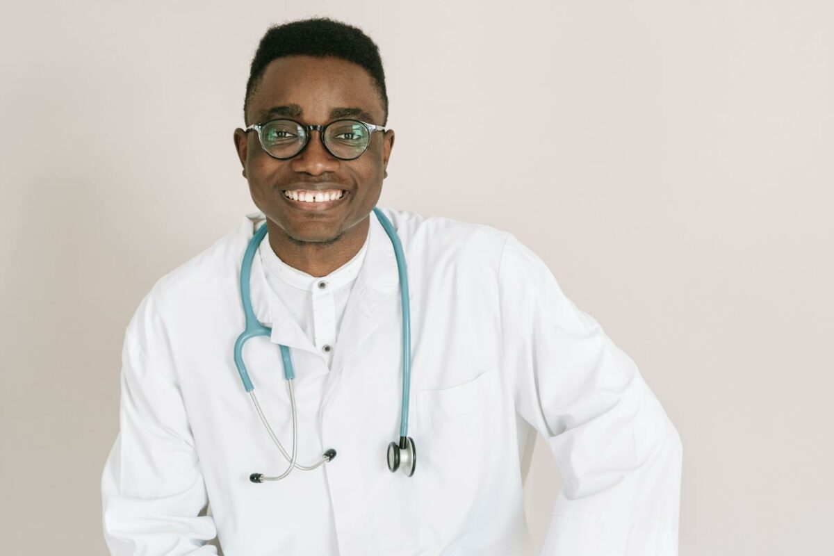 Cheerful male doctor wearing eyeglasses and a stethoscope, illustrating health care professionalism.